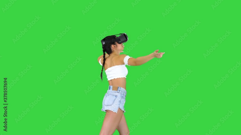 Woman using VR Virtual Reality headset walking and dancing on a Green Screen, Chroma Key. Woman using VR Virtual Reality headset walking and dancing on a Green Screen, Chroma Key.