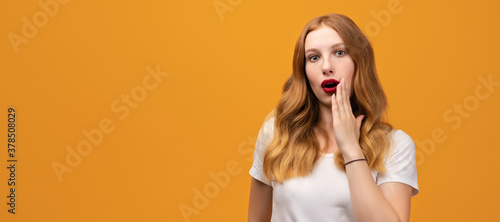 Shocked and surprised girl looking at camera wearing white t-shirt. Copy space