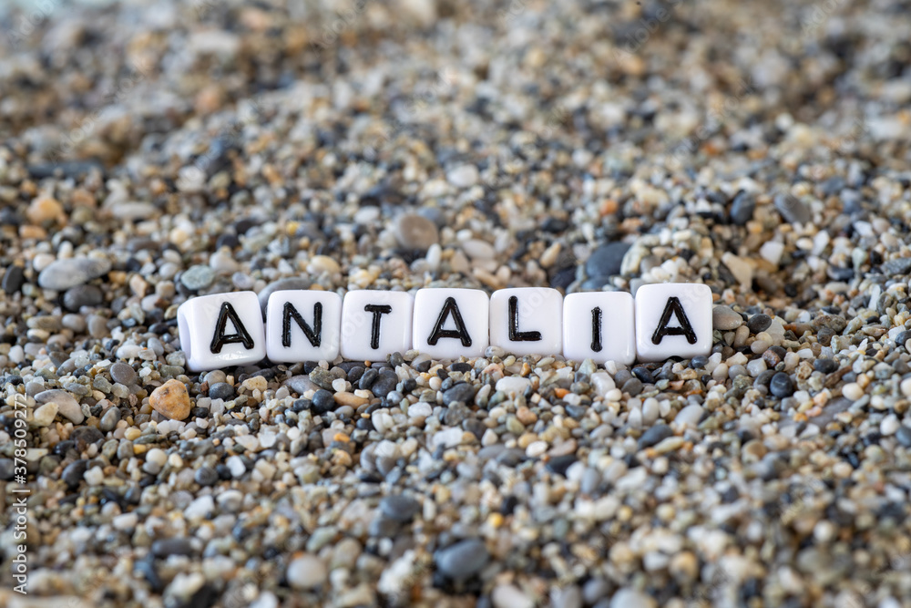 Antalia inscription text with name of the vacation destination city in a still life of the letters layed out on a shore sand stones. Antalia inscription text with name of the vacation destination city in a still life of the letters layed out on a shore sand stones.