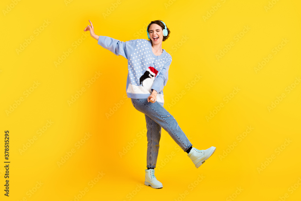 Full length photo of attractive crazy lady youth party newyear discotheque listen cool modern technology earphones dance floor wear ugly sweater jeans shoes isolated yellow color background