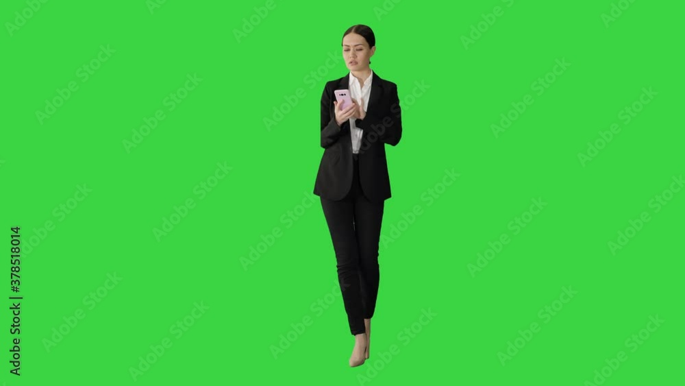Disapprovingly looking business woman using her phone on a Green Screen, Chroma Key. Disapprovingly looking business woman using her phone on a Green Screen, Chroma Key.