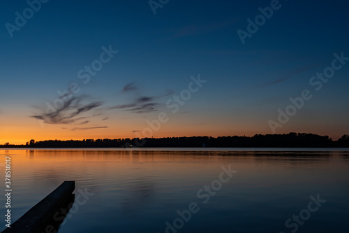 Just after sunset, the sky colors beautifully above lake Zoetermeerse plas with a breakwater in the foreground
