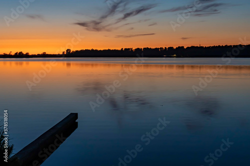 Just after sunset, the beautifully colored sky and clouds are reflected in the water of lake Zoetermeerse plas photo
