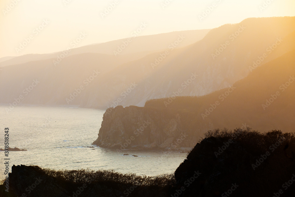 Sikhote-Alin Biosphere Reserve in the Primorsky Territory. The rays of the setting sun make their way through the rocky coast of the reserve