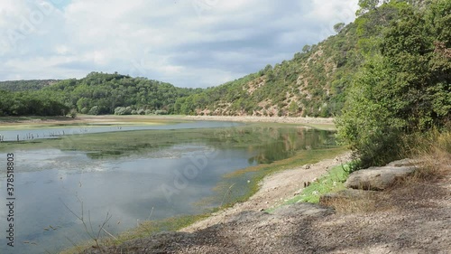 Video of The lake of Sainte Suzanne called lac de Carcès along forestry path with view on low water level when the dam is drained or pumped water in dry period photo