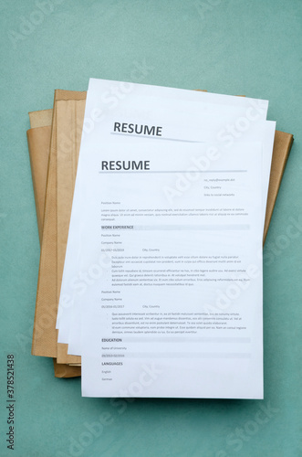 Vertical image.Top view of stack of resume forms and folders on the office blue desk