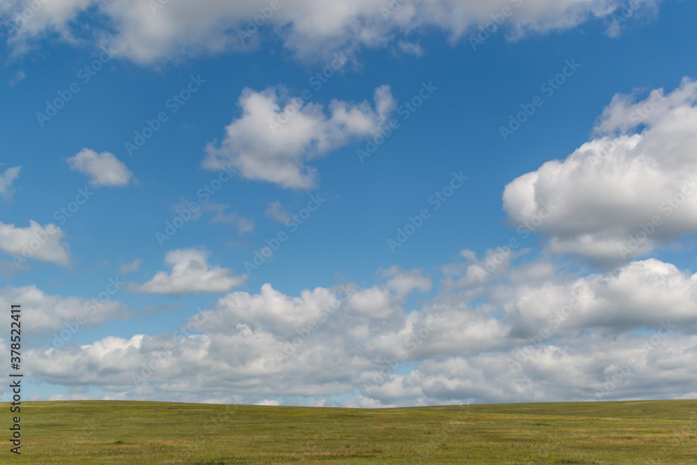 bright white fluffy clouds in blue sky with green field, open space bright white fluffy clouds in blue sky with green field, open space