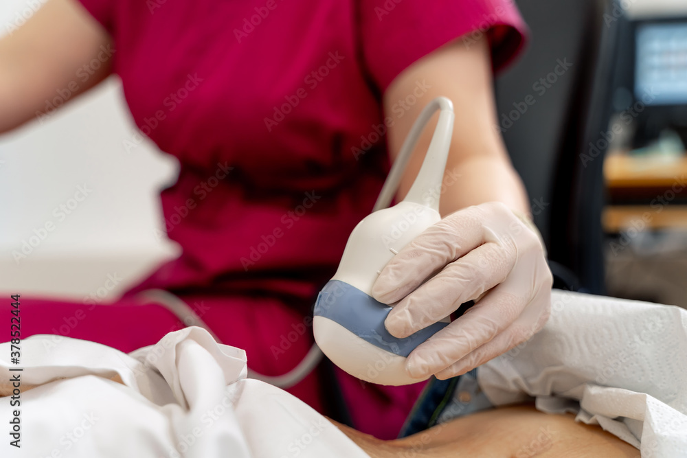 Skillful sonographer using ultrasound machine at work. Selective focus on hand. Modern clinic. Skillful sonographer using ultrasound machine at work. Selective focus on hand. Modern clinic.