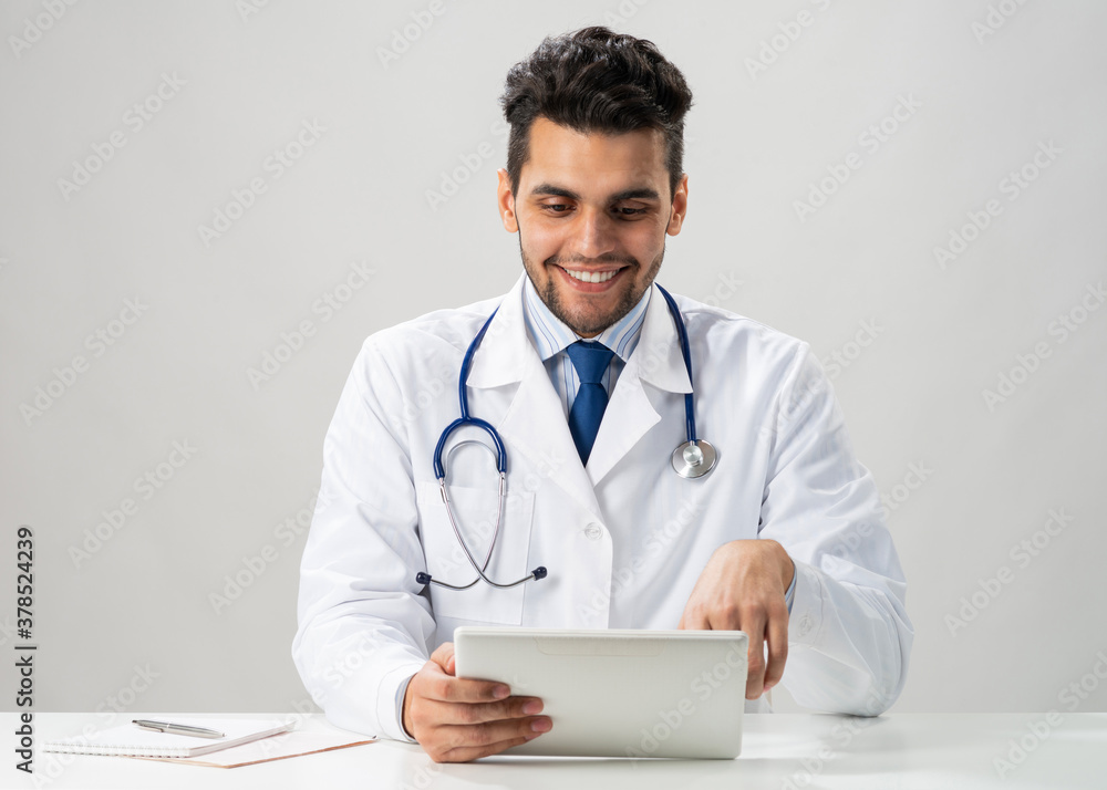 Young smiling internist using tablet computer Young smiling internist using tablet computer