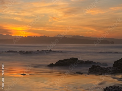 Golden reflection of the sunset on Liencres beach