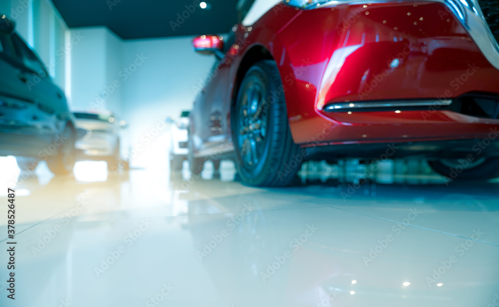 Blurred red and white car parked in modern showroom. Car dealership and auto leasing concept. Automotive industry. Modern luxury showroom. New car global market trends topics background.