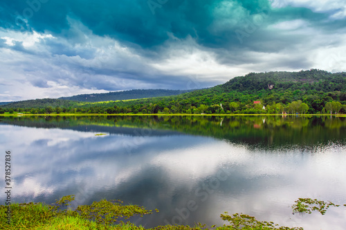 Landscape of green and calm nature with water lake forest mountain and dramatic blue sky