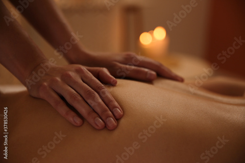 Fotografie Young woman receiving back massage in spa salon, closeup