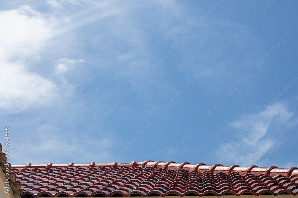 Gray tile roof of construction house with blue sky.