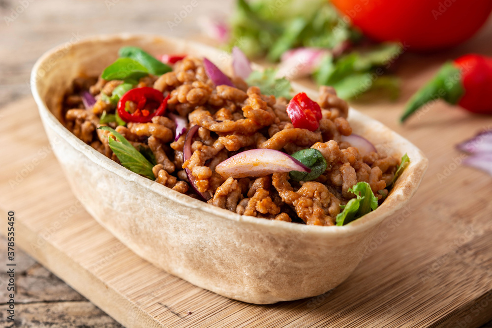 Mexican barquita taco with beef, chilli, tomato, onion and spices on wooden table Mexican barquita taco with beef, chilli, tomato, onion and spices on wooden table