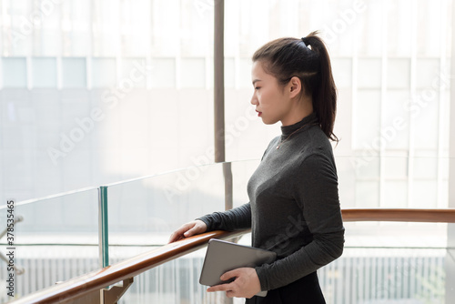 Young lady with tablet computer staring into the distance Free Download Young lady with tablet computer staring into the distance - GFXLoad