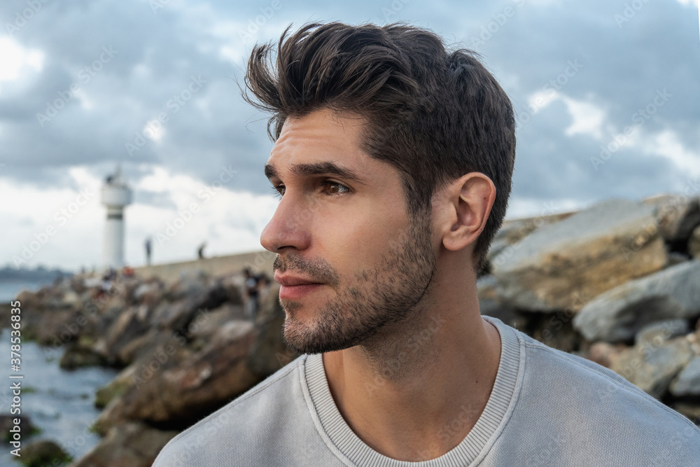 Portrait of a young handsome latin man with a beard and confident look on the beach Portrait of a young handsome latin man with a beard and confident look on the beach