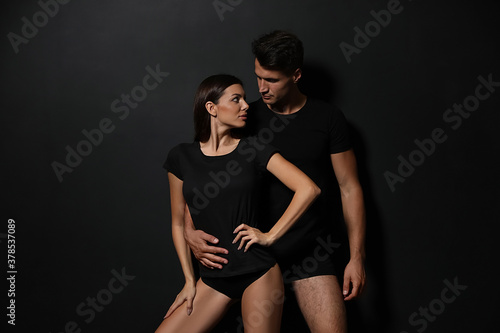 Young couple wearing underwear on black background