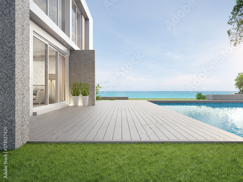 Empty outdoor wooden floor terrace near swimming pool and green grass garden in modern beach house or luxury villa. Building exterior 3d rendering with sea view. photo
