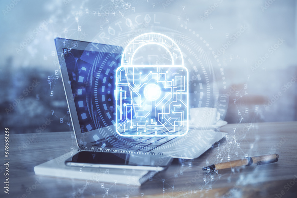 Double exposure of desktop with computer and lock icon hologram. Concept of data safety.