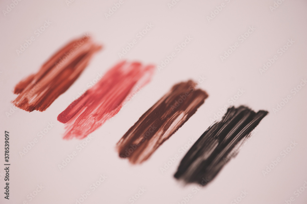 Swatches of colorful liquid lipstick over white closeup. Selective focus. Swatches of colorful liquid lipstick over white closeup. Selective focus.