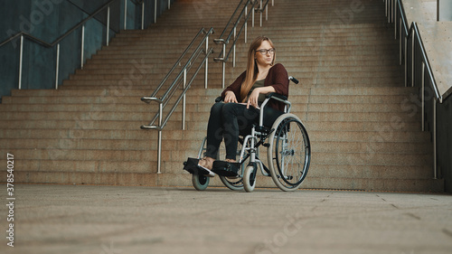 Hopeless young woman in the wheelchair in front of the inaccessible stairs. High quality photo © CameraCraft