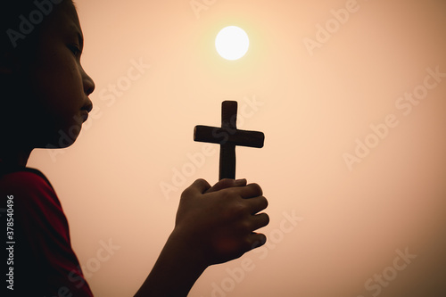 A boy is praying seriously and hopefully to Jesus.