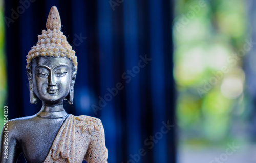 Statue of Buddha sitting in meditation With  space on the right hand side Fototapeta
