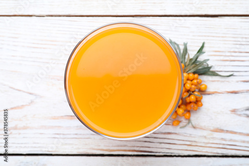 Delicious sea buckthorn juice and fresh berries on white wooden table, top view