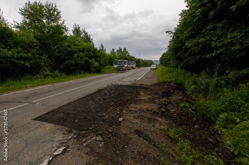 Very bad road in Russia. The asphalt road is all in holes in the middle of the forest.