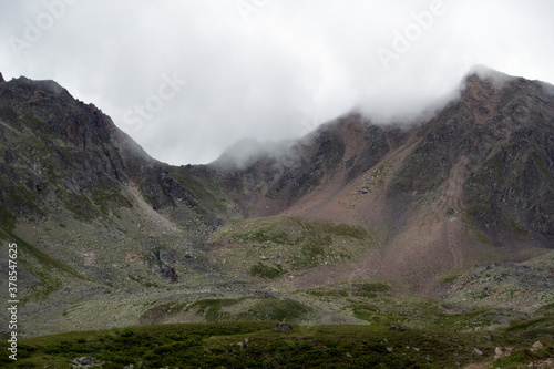 Mountain range in the clouds. Mountain pass in the fog. Pass Pastushiy (3244 meters above sea level), Caucasus.
