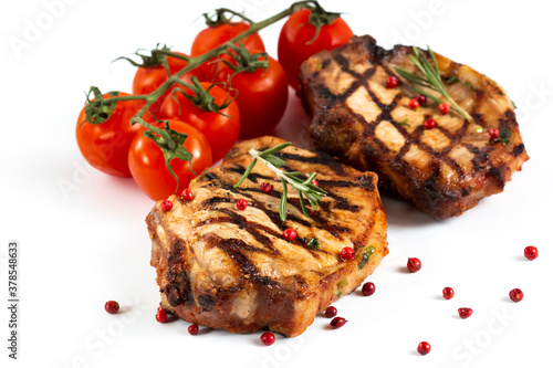 Grilled pork chops with vegetables-cherry tomatoes, peppers, parsley on a wooden Board. Isolate.