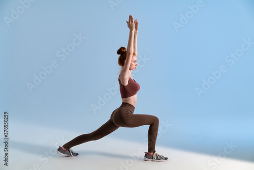 Photo of young focused sportswoman doing exercise while working out