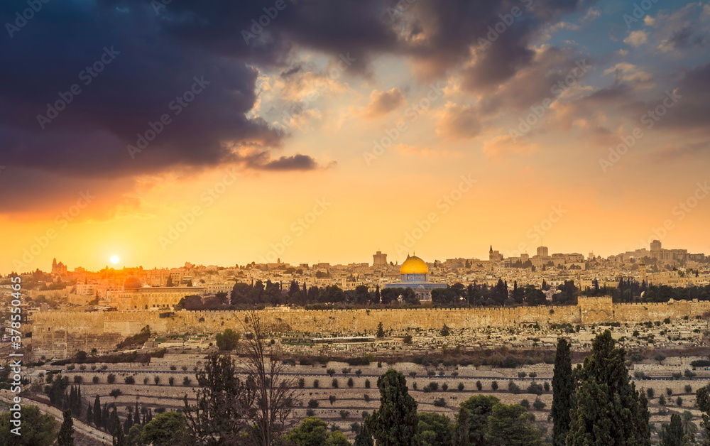 Fototapeta premium Dramatic sunset sky over Mount Zion and Old City Jerusalem; view of the Temple Mount with Dome of the Rock and Golden Gate, Kidron Valley in the foreground, and the skyline of West Jerusalem