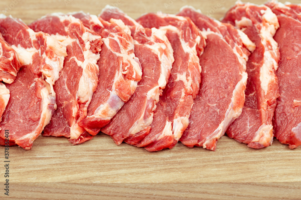 Fresh raw  beef steak on a wooden cutting board close-up.