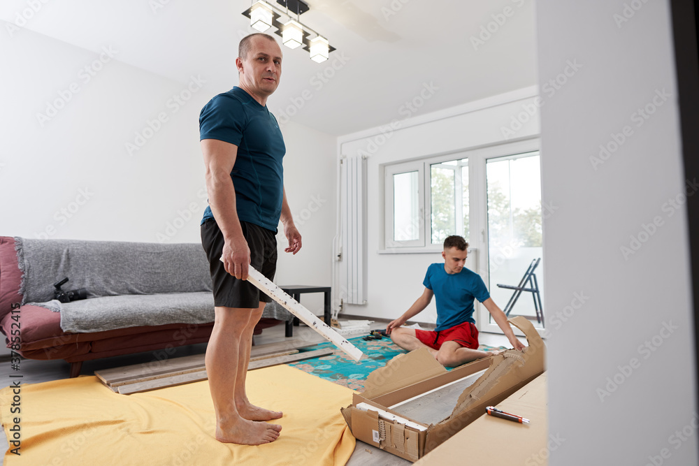 Father and son assembling furniture in new home
