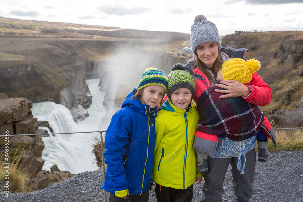 Mother with children, enjoying the big majestic Gullfoss waterfall in mountains in Iceland Mother with children, enjoying the big majestic Gullfoss waterfall in mountains in Iceland