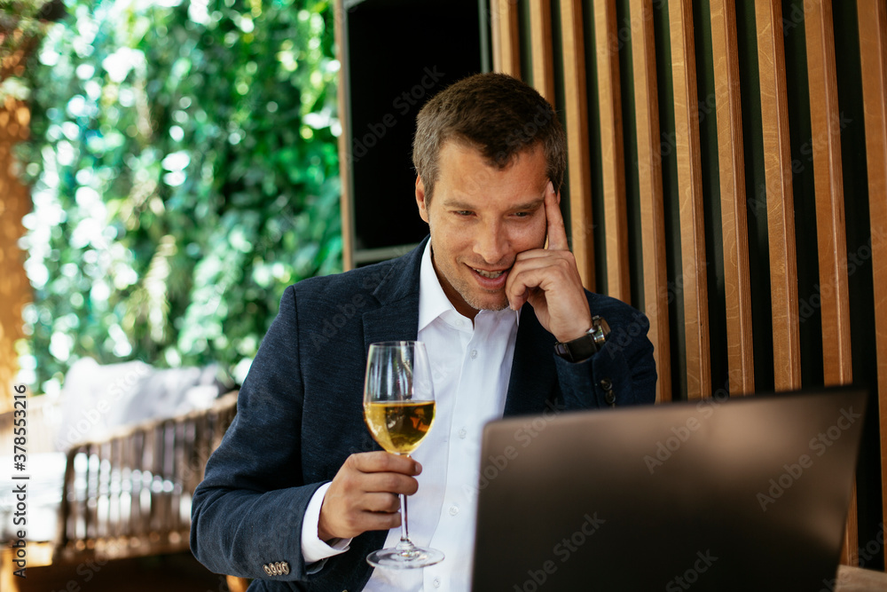 Handsome businessman dressed in the suit drinking wine. Businessman enjoying in the restaurant. Handsome businessman dressed in the suit drinking wine. Businessman enjoying in the restaurant.