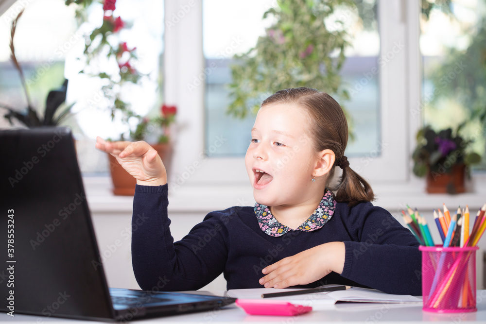 Study online with video call teacher. Young girl learn online and looking at laptop at home.Social distancing. Study online with video call teacher. Young girl learn online and looking at laptop at home.Social distancing.