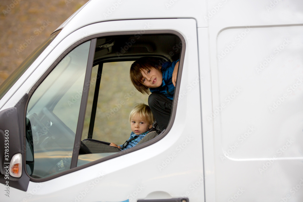 Cute boys, children in camper van traveling around Iceland autumntime