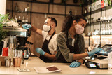 Two baristas wearing medical mask serving coffee
