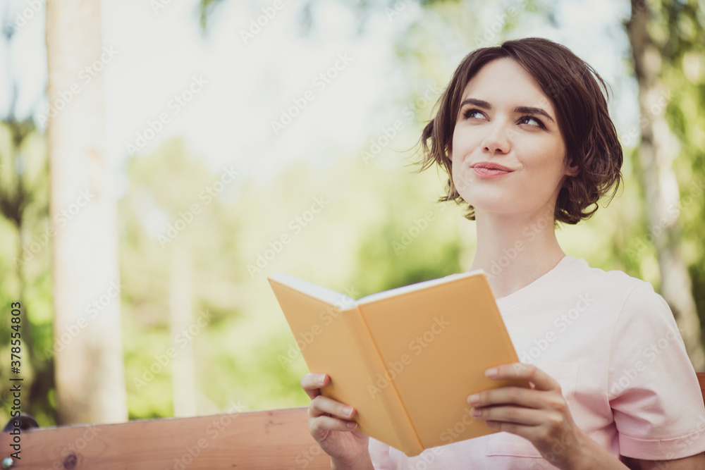 Fototapeta premium Photo of charming lovely pretty lady dreamy inspired look thinking if dragons real want ride one sitting bench read fantasy novel textbook imagining wear white shirt outdoors