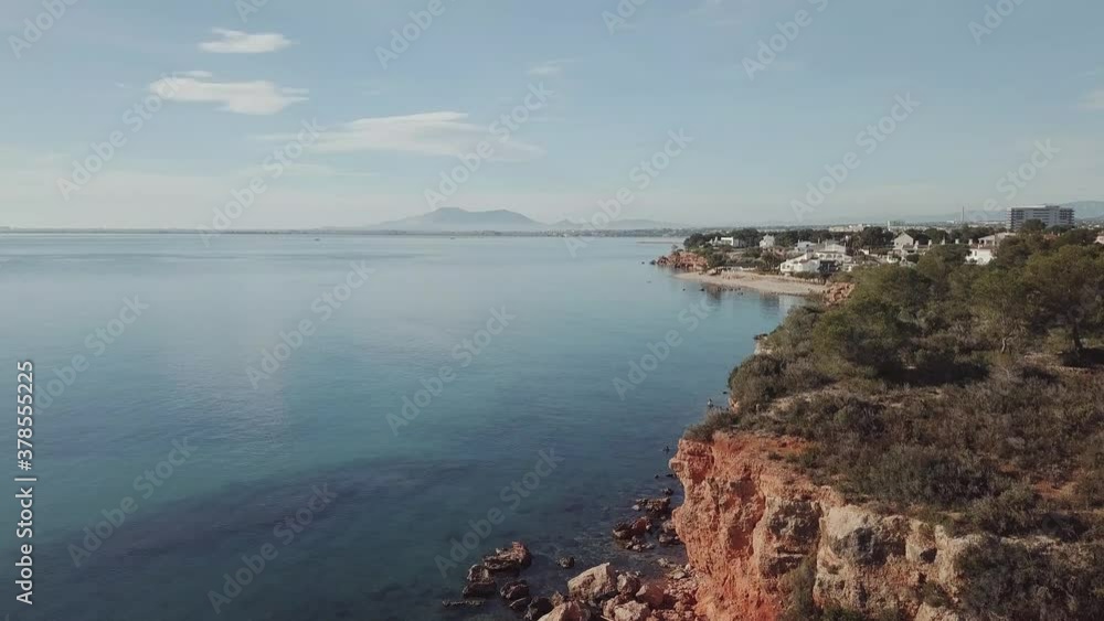 Astonishing tilt up view of a completely still sea and small cliff Astonishing tilt up view of a completely still sea and small cliff