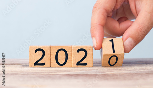 Hand Changing Date From 2020 To 2021 On Wooden Cube Calendar / New Year's Concept
