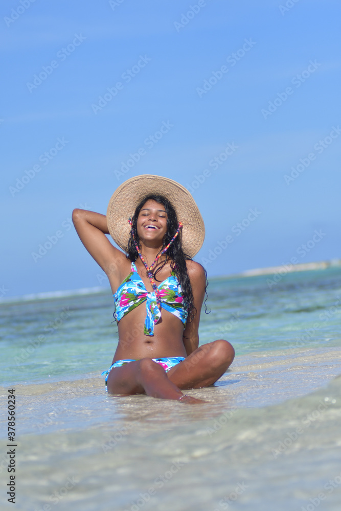 Young African American woman relaxing siting on shore beach with smile and close eyes. Happiness Concept