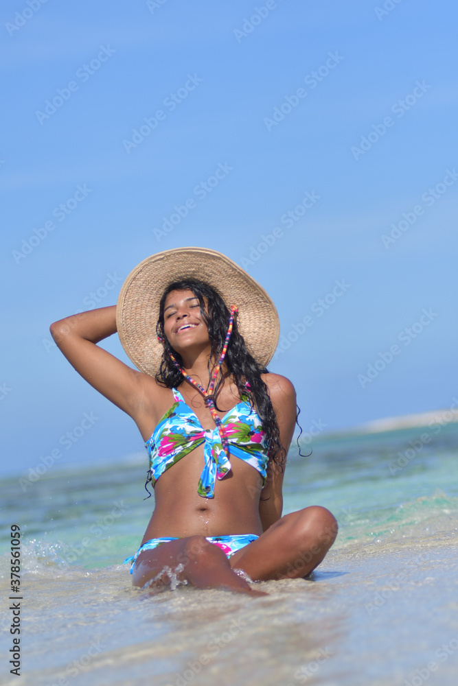 Young African American woman siting on shore beach laughing with close eyes splash water. Happiness Concept