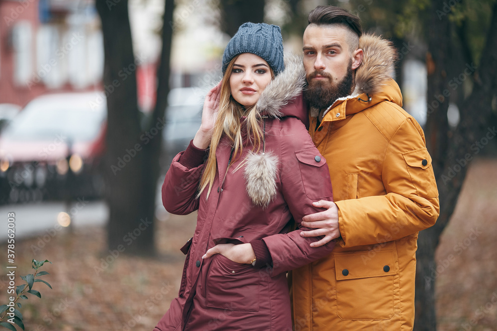A cheerful guy and a girl are walking in the autumn park A cheerful guy and a girl are walking in the autumn park