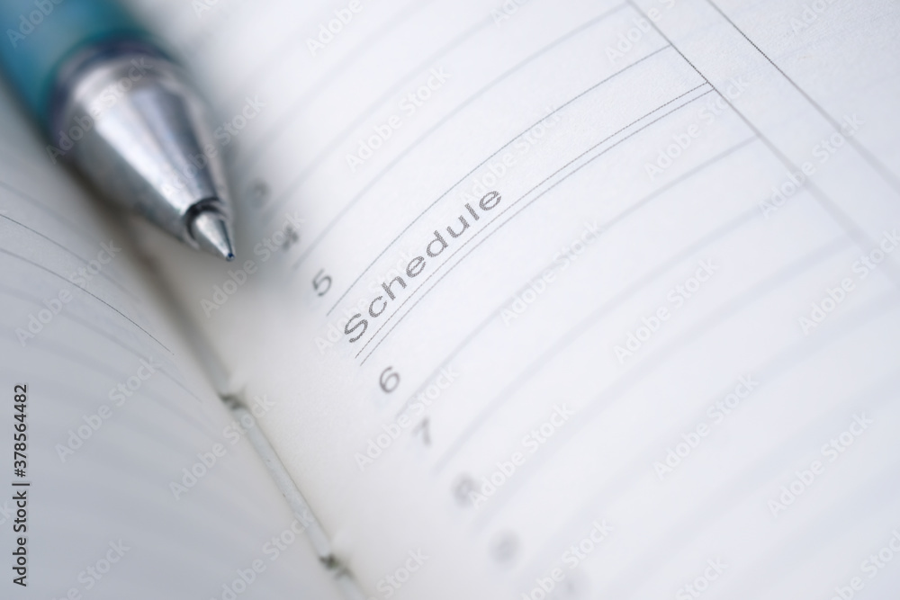 open notepad with schedule word on paper open notepad with schedule word on paper
