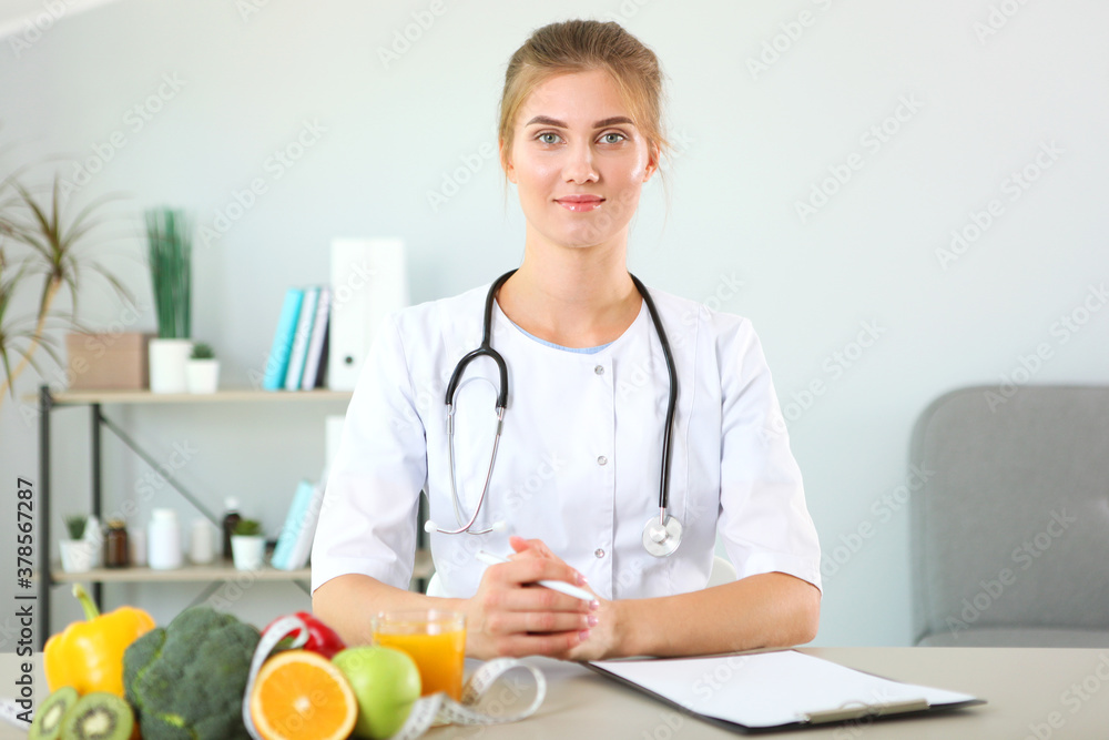 young doctor nutritionist in his office demonstrates the concept of healthy eating. Help with weight control young doctor nutritionist in his office demonstrates the concept of healthy eating. Help with weight control
