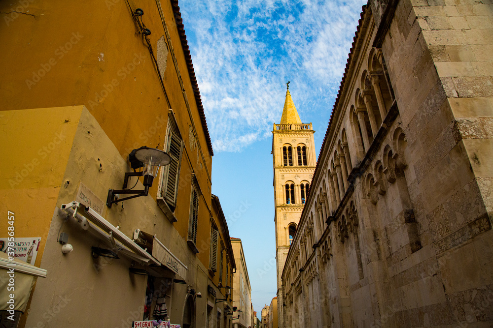 Calles estrecha y fachada lateral con arcos de catedral de Zadar
